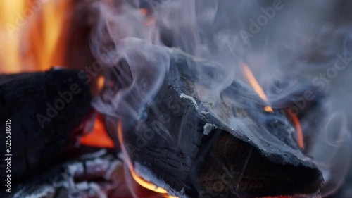 Smokey burning wood and embers in slow motion