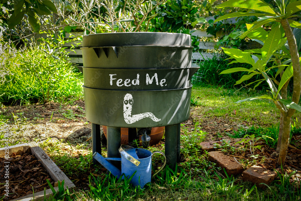 Worm farm compost bin in organic Australian garden with Feed Me worm sign, sustainable living and zero waste lifestyle