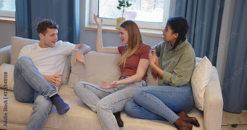 Young attractive smiling man says a funny story his girlfriends and they laughing