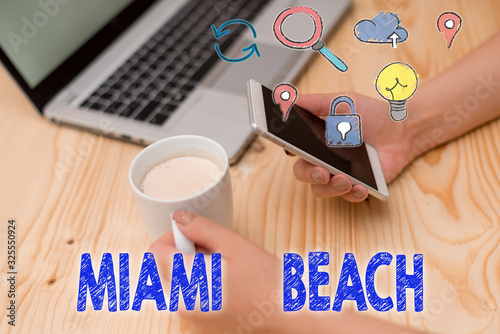 Writing note showing Miami Beach. Business concept for the coastal resort city in MiamiDade County of Florida photo