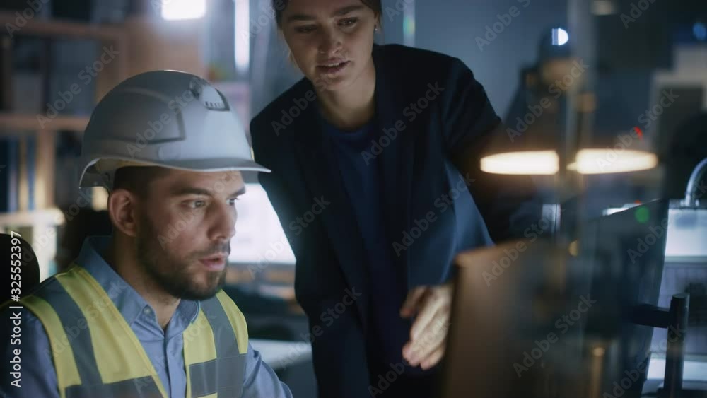 Modern Factory Office: Female Project Manager Talks to a Male Industrial Engineer who Works on Computer. Professional Teamwork, Specialists Solving Problems, Finding Solutions Modern Factory Office: Female Project Manager Talks to a Male Industrial Engineer who Works on Computer. Professional Teamwork, Specialists Solving Problems, Finding Solutions