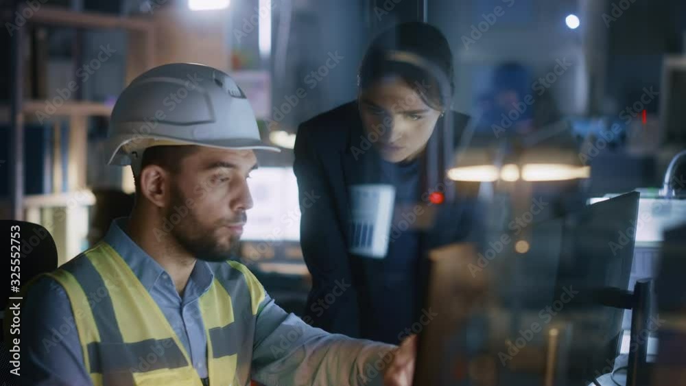 Modern Factory Office: Female Project Manager Talks to a Male Industrial Engineer who Works on Computer. Professional Teamwork, Specialists Solving Problems, Finding Solutions