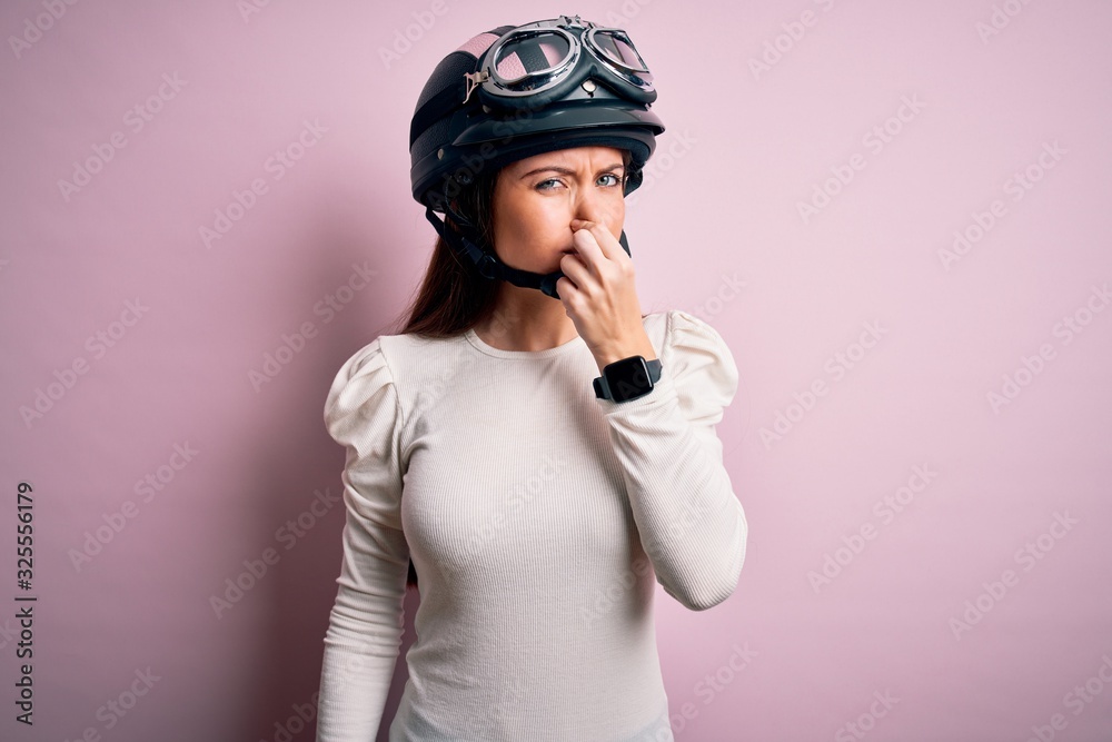 Young beautiful motorcyclist woman with blue eyes wearing moto helmet