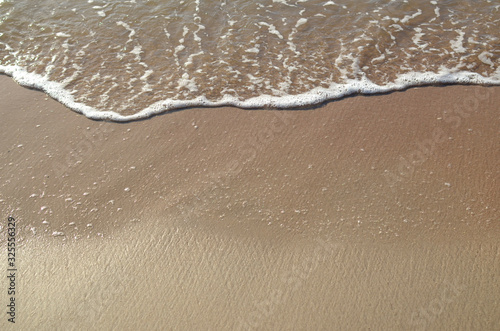 Ocean wave on sandy beach, background