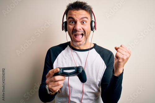 Free Photo  Player winning video games with controller and headset in  front of monitor. man using joystick and headphones, playing online games  on computer. person celebrating game win for leisure.