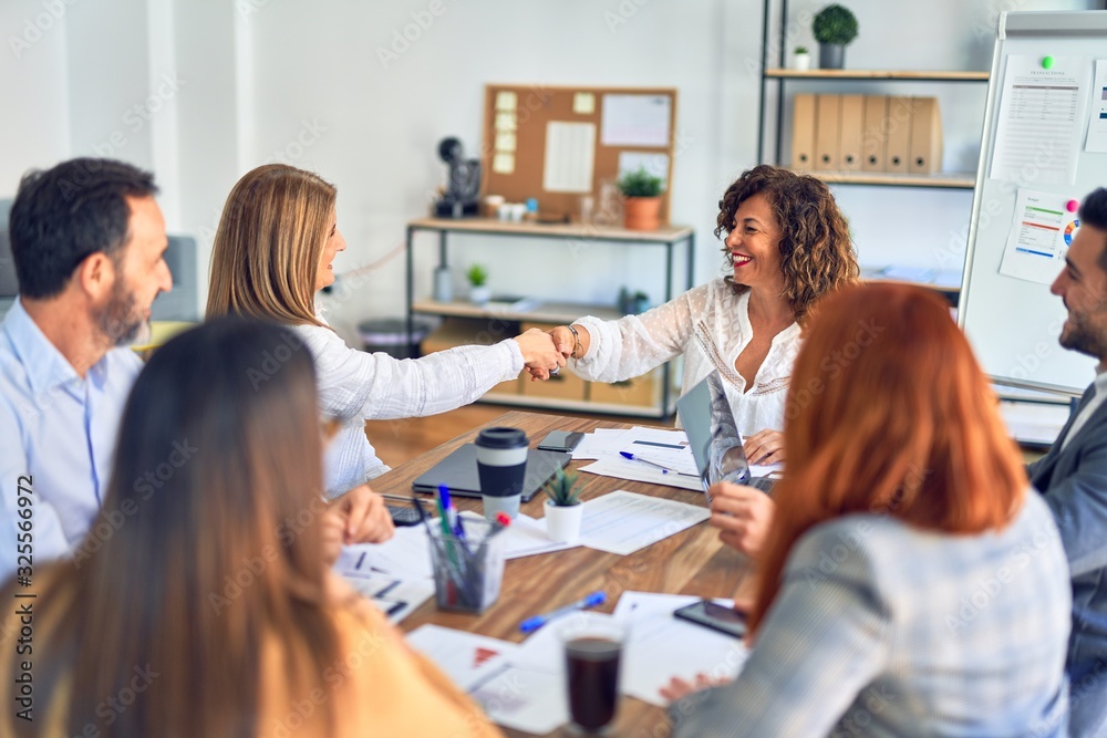 Group of business workers smiling happy and confident. Working together with smile on face shaking hands at the office Group of business workers smiling happy and confident. Working together with smile on face shaking hands at the office