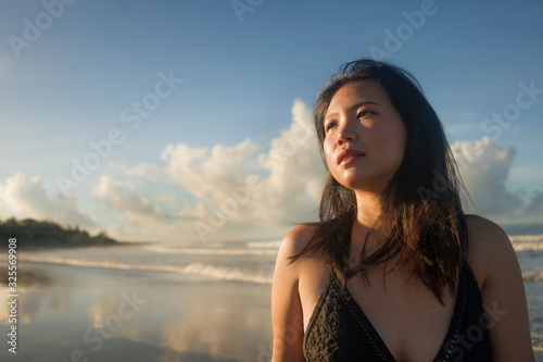 young attractive and cool Asian Chinese woman in swimsuit walking on beautiful beach paradise feeling relaxed and cheerful enjoying holidays in exotic travel destination