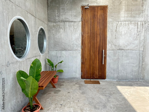 Wallpaper Mural Wooden chair and door with green plants pot and Bare cement walls background. Torontodigital.ca