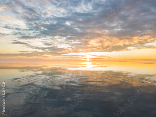 Beautiful sunrise over sea with reflection in water.