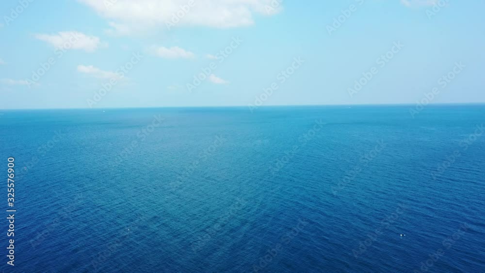 Abstract deep sea background. Aerial backwards revealing bright blue sky with white clouds Abstract deep sea background. Aerial backwards revealing bright blue sky with white clouds