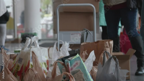 Volunteers fill grocery bags full of food donations to hand out to needy
