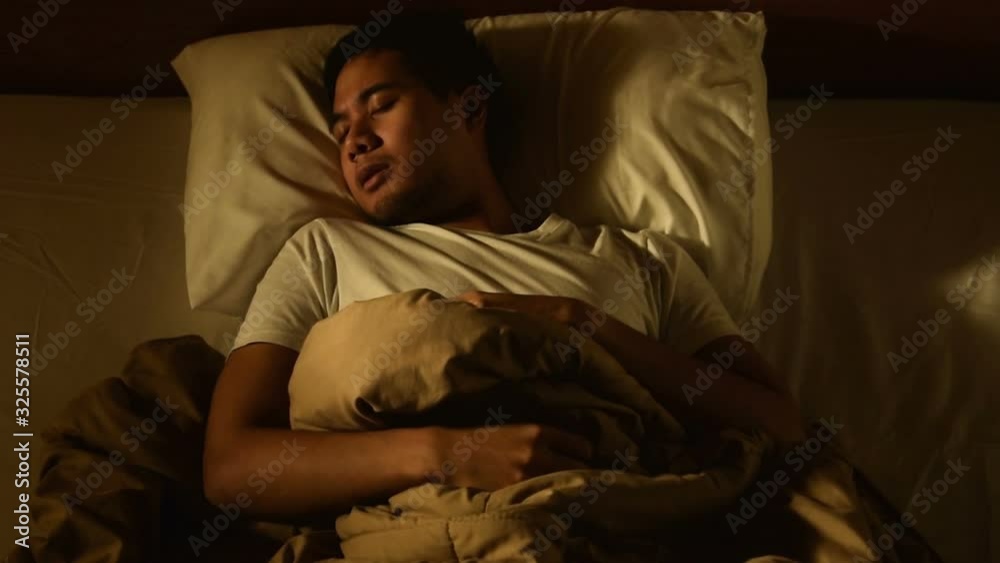 Young man in bed suffering insomnia. Nightmare issues . Young man in bed suffering insomnia. Nightmare issues .