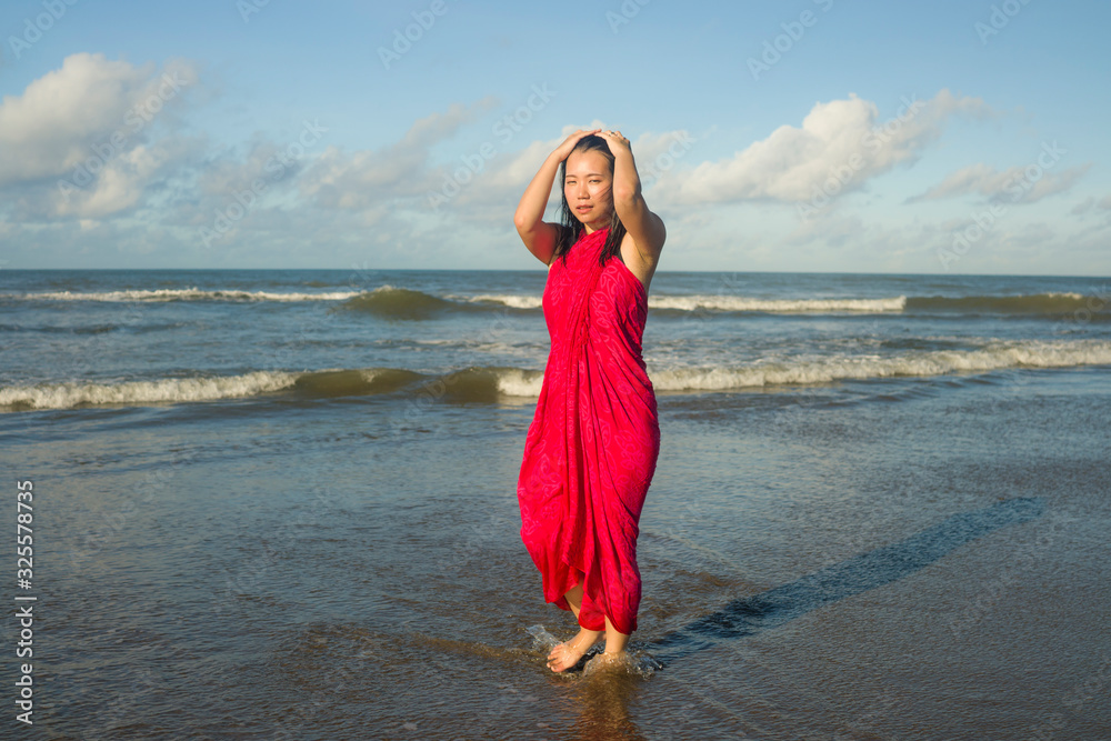 young sweet and happy Asian Chinese woman in sarong at beautiful beach walking by the sea relaxed and blissful enjoying Summer holiday travel feeling free in Asia travel young sweet and happy Asian Chinese woman in sarong at beautiful beach walking by the sea relaxed and blissful enjoying Summer holiday travel feeling free in Asia travel