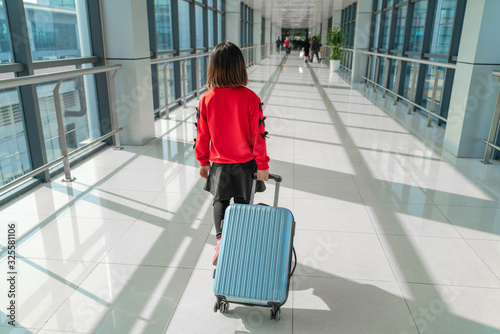 Little girl with travel luggage in the airport