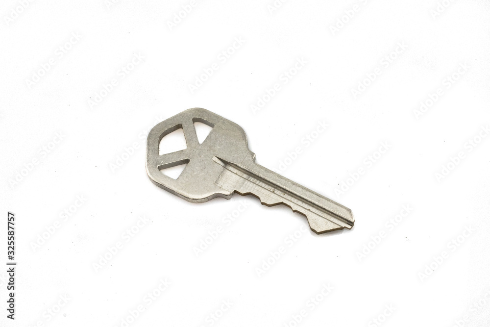 A silver house key, close up, isolated on a clean, white background. Shot in macro. A silver house key, close up, isolated on a clean, white background. Shot in macro.