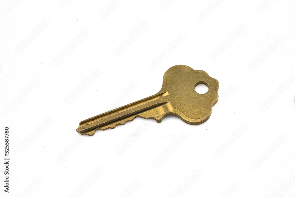 A gold house key, close up, isolated on a clean, white background. Shot in macro. A gold house key, close up, isolated on a clean, white background. Shot in macro.