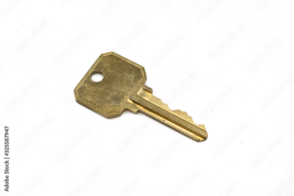 A brass security door key, close up, isolated on a clean, white background. Shot in macro. A brass security door key, close up, isolated on a clean, white background. Shot in macro.