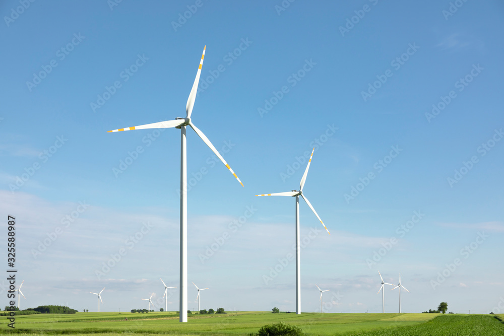 wind turbines in green field, countryside area with blue sky wind turbines in green field, countryside area with blue sky