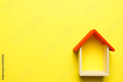 home replica on yellow background. copy space. flat lay
