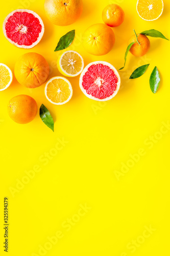 Fototapeta Naklejka Na Ścianę i Meble -  Fresh citrus frame. Oranges, tangerines, grapefruits, leaves on yellow background top-down copy space