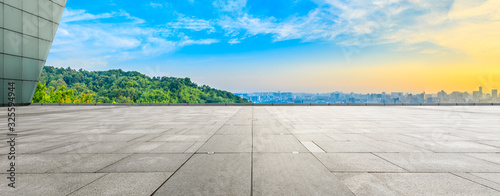 Wide square floor and city skyline with green mountain at sunrise in Hangzhou,China.