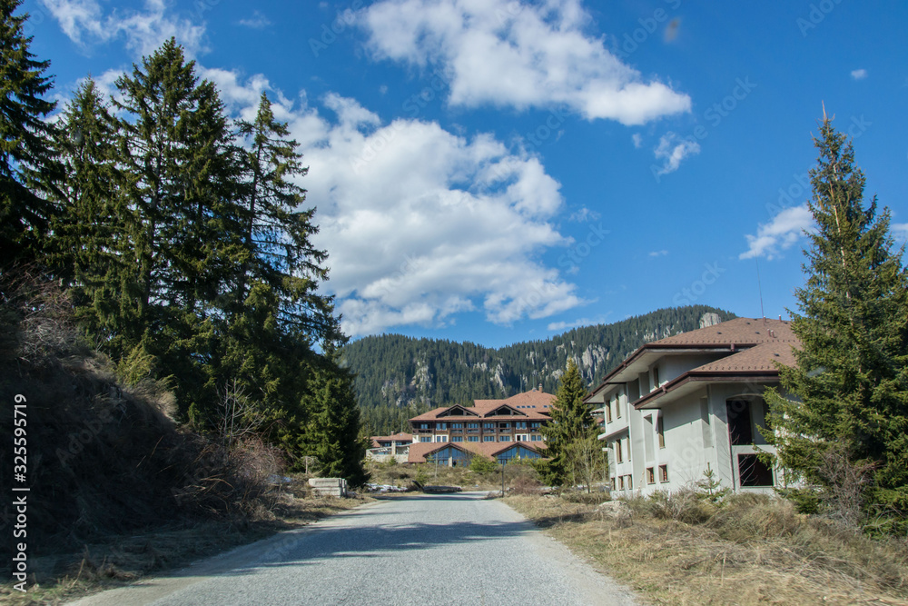 March 25, 2019 - Smolyan, Bulgaria - Road in the mountains with hotels on the side, beautiful blue sky, forest, trees