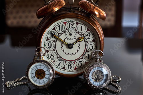 A vintage alarm clock with old pocket watches