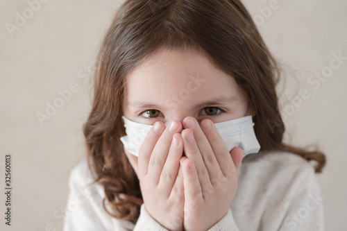 coronavirus COVID-19 epidemic outbreak quarantine concept of small ill kid in medical mask wants to sneeze