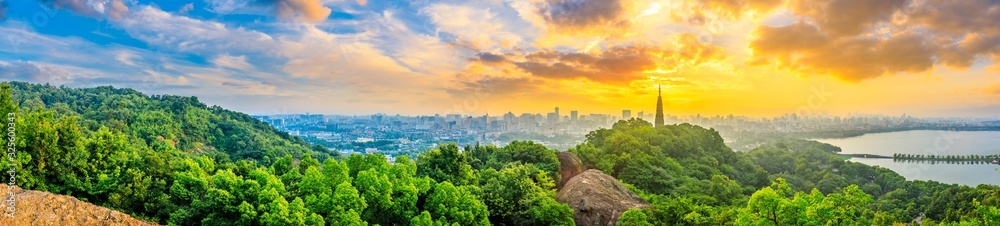 Panoramic city skyline and green mountains at sunrise in Hangzhou,China.