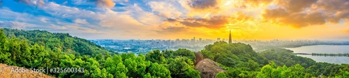 Panoramic city skyline and green mountains at sunrise in Hangzhou,China.