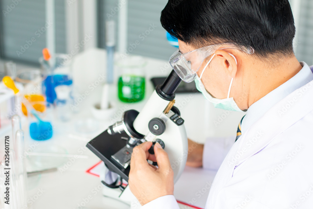 Asian male scientist look through the microscope in the laboratory. Asian male scientist look through the microscope in the laboratory.