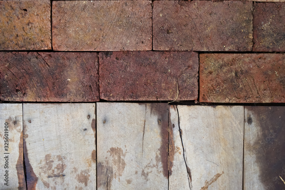 Selective focus image a combination texture of red brick and old wooden floor panel, photographed at close range with natural light. Selective focus image a combination texture of red brick and old wooden floor panel, photographed at close range with natural light.
