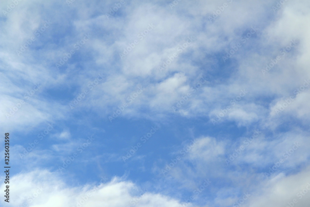 Cloudy blue sky with white and gray clouds. Background for text and design