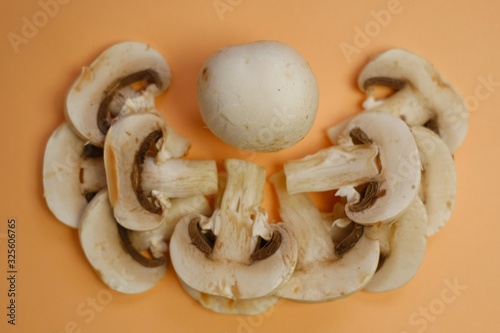  Champignon raw vegetable. Mushroom pattern. cut slices of mushrooms on a light beige background.