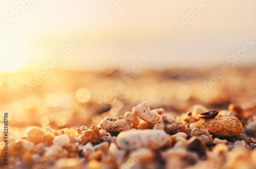 Tropical sunset beach with smooth wave and bokeh sunlight abstract background.