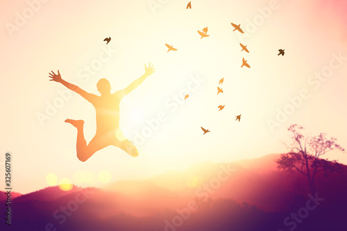 Silhouette man jump and birds fly on sunset sky and cloud texture abstract background.