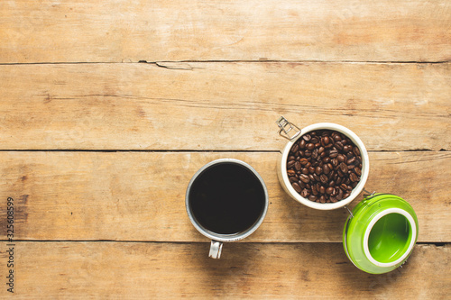 cup with fresh coffee and a can with coffee grains on a wooden table. Banner. Coffee concept, plantation, processing, collection. Top view, flat lay