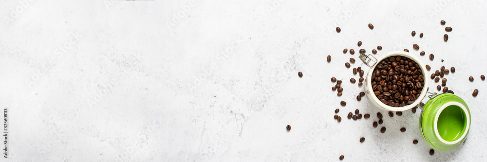 Fototapeta premium can with coffee and coffee beans scattered on a concrete background. Banner. Concept of fresh coffee, breakfast, plantation. Top view, flat lay