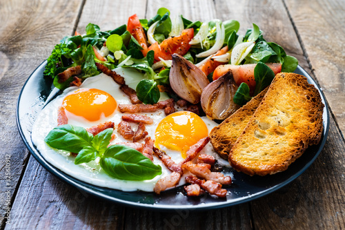 Fototapeta Naklejka Na Ścianę i Meble -  Continental breakfast - sunny side up eggs ,toasts and vegetable salad