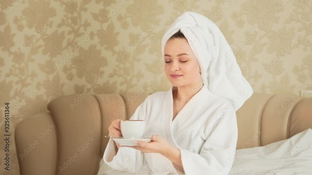 handsome sporty guy in a robe supplies coffee to a girl in bed handsome sporty guy in a robe supplies coffee to a girl in bed
