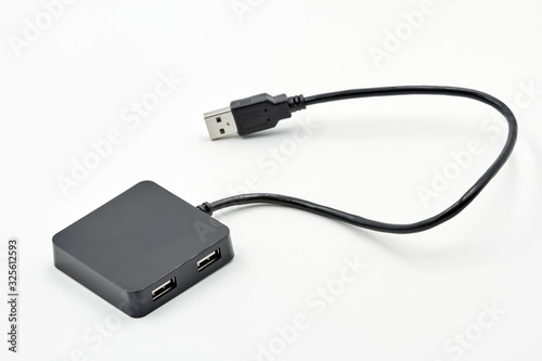 Black portable USB hub for four connections on a white background. Bus povered.