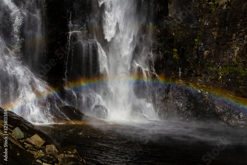 Skjervsfossen Waterfall with a rainbow in Norway. Travel destination.