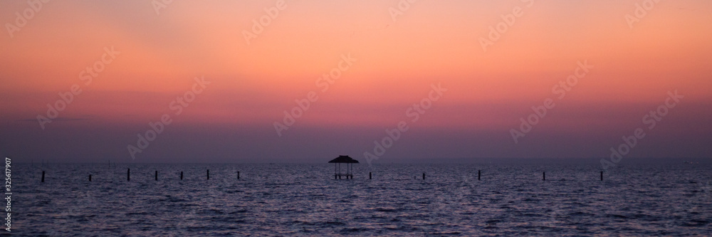 hut on the horizon during sunset hut on the horizon during sunset