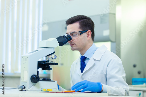 Scientist studies properties and benefits of omega 3 fatty acids using microscope and laboratory equipment in a medical laboratory