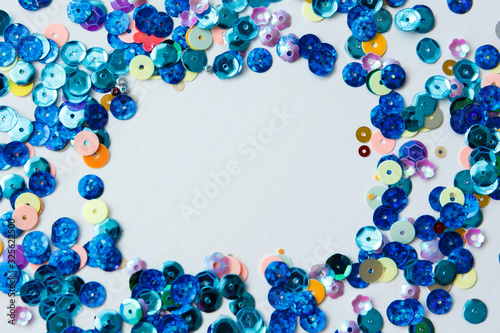 Colored and blue sequins on a white background