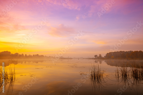Magic sunrise over the lake. Misty early morning, rural landscape, wilderness, mystical feeling. Serenity lake in magical light