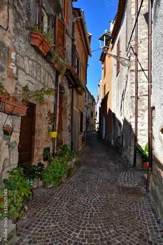 Fototapeta Naklejka Na Ścianę i Meble -  Collepardo, Italy, 02/22/2020. An alley between the old stone houses of a medieval village.