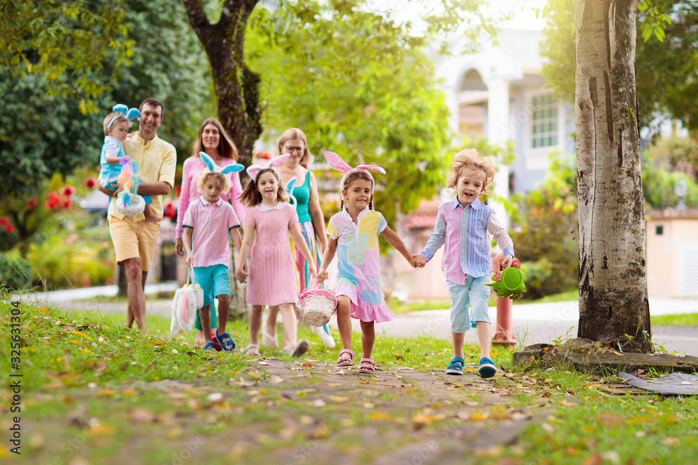 Obraz premium Family with kids on Easter egg hunt