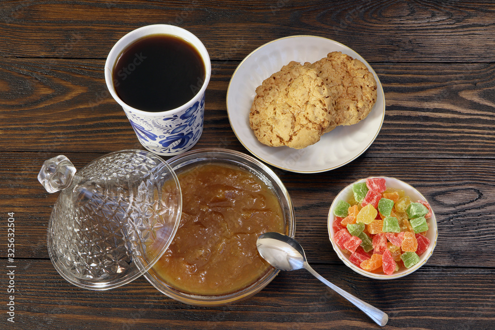 Breakfast. A cup of coffee, cookies, candied fruits and jam on a wooden table. Breakfast. A cup of coffee, cookies, candied fruits and jam on a wooden table.