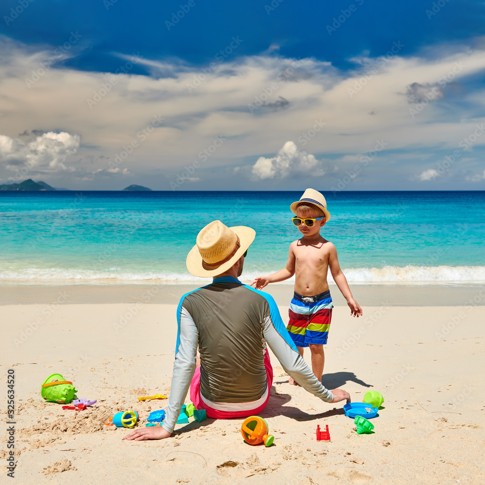 Toddler boy on beach with father Toddler boy on beach with father